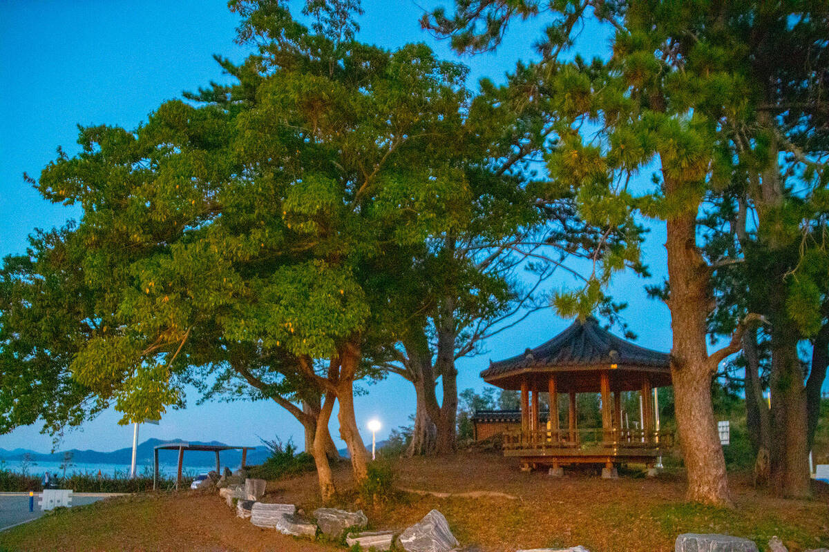 어두워지고 있는 하늘 아래 정자가 세워져 있는 모습
