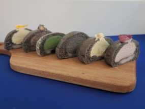 몽돌빵이 나무도마위에 반으로 잘려져 올라가있는 이미지