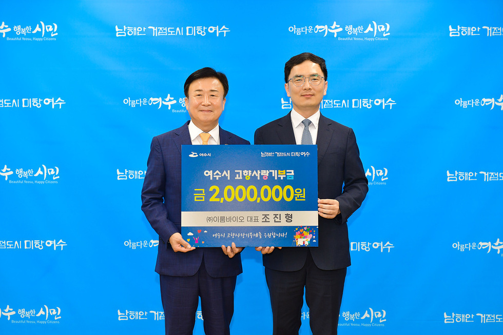 여수시에서 고향사랑기부금 200만원 기부를 기념하는 행사에서 두 남성이 기념사진을 찍고 있다.