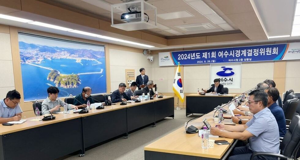 여수시청 2층 상황실에서 2024년도 제1회 여수시경계결정위원회가 열리고 있으며, 참석자들이 회의에 집중하고 있다.
