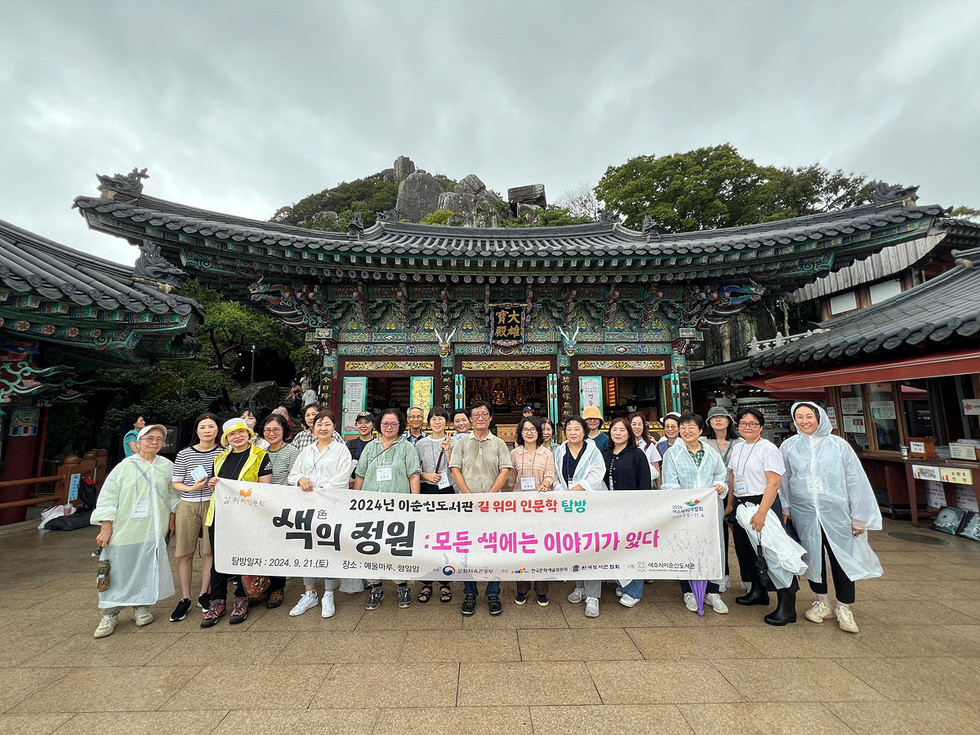 2024년 이순신도서관 길 위의 인문학 탐방에 참여한 사람들이 향일암 앞에서 기념사진을 찍고 있다.