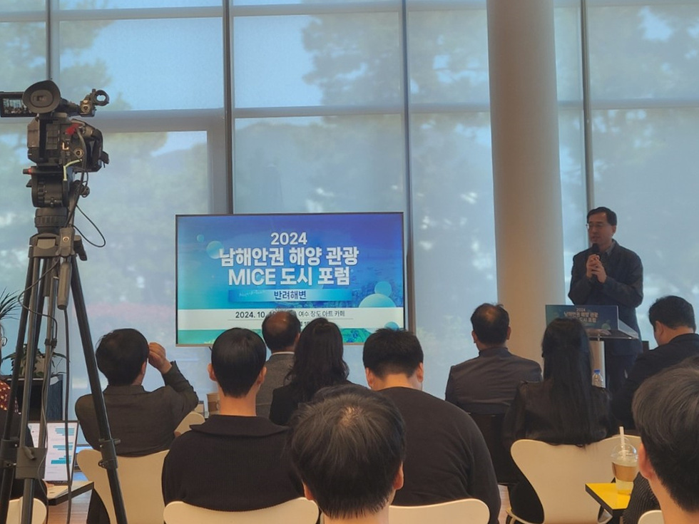 남해안권 해양 관광 MICE 도시 포럼에서 발표자가 마이크를 들고 발표하고 있으며, 청중이 경청하고 있는 모습이다.