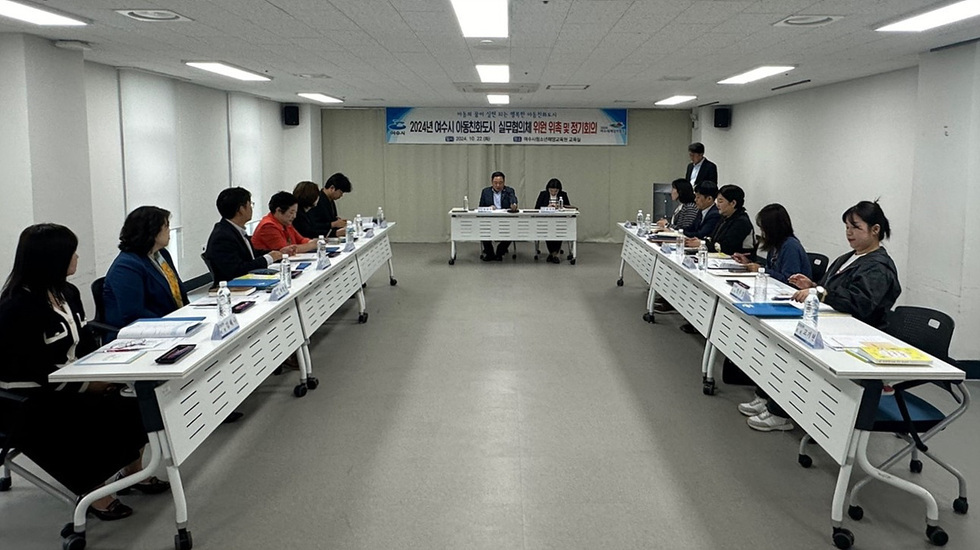 여수시 아동통합지원 심의위원회가 정기회의를 진행하는 모습으로, 여러 위원들이 테이블에 앉아 회의 자료를 검토하고 있다.