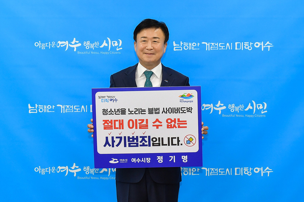 여수시장이 불법 사이버 도박의 위험성을 알리는 현수막을 들고 있는 모습으로, 청소년을 대상으로 한 사기 범죄에 대한 경각심을 촉구하고 있다.
