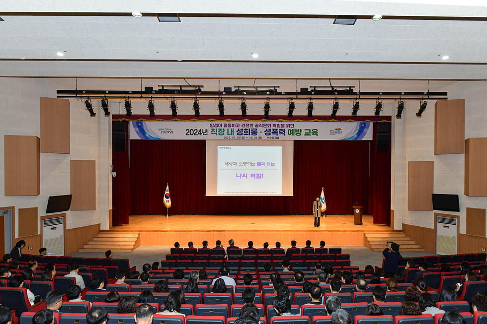 2024년 직장 내 성희롱과 성폭력 예방 교육이 진행되고 있는 강당의 모습으로, 강사가 무대에서 교육을 진행하고 있다.