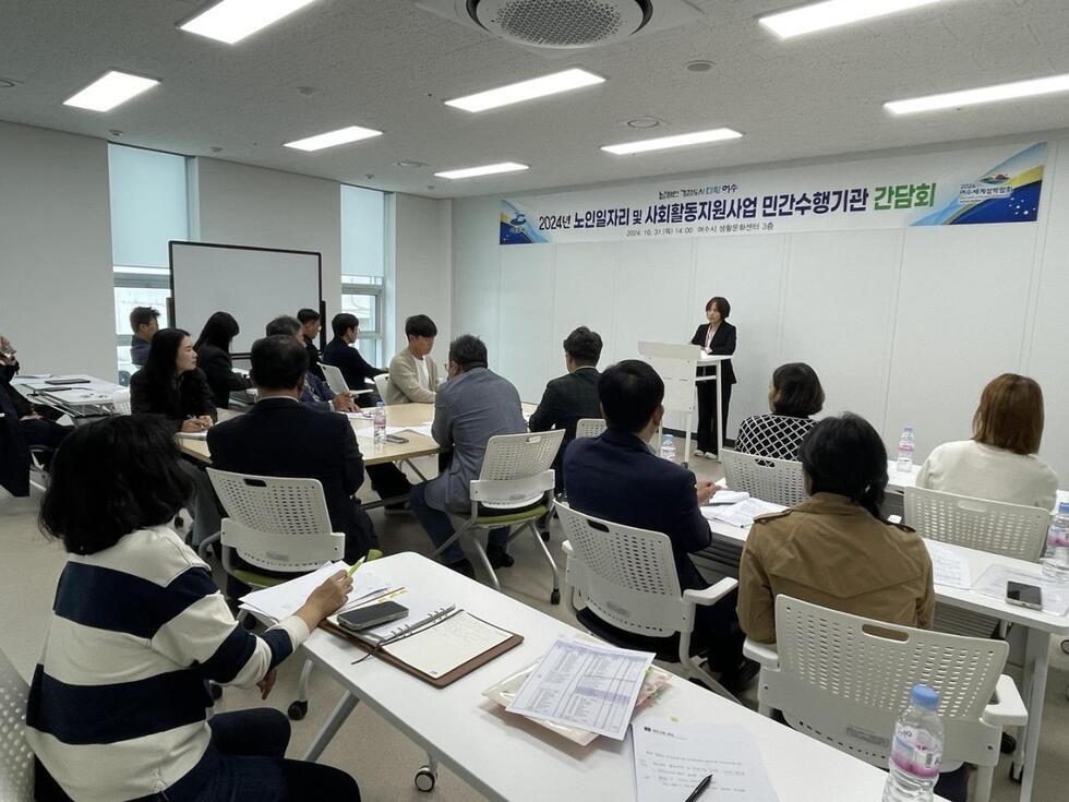 2024년 노인일자리 및 사회활동지원사업에 관한 민간수행기관 간담회가 아시안문화원에서 열리고 있으며, 발표자가 무대에서 발표하고 있다.