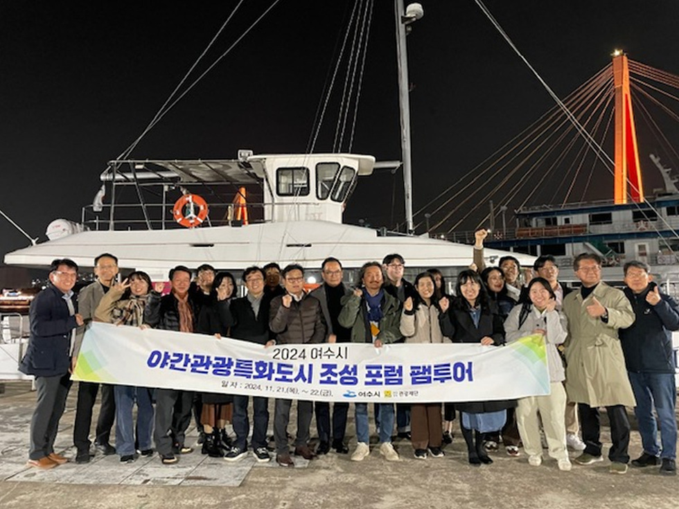 2024 여수시 야간관광특화도시 조성 포럼 팸투어에 참여한 사람들이 배 앞에서 기념사진을 찍고 있다.