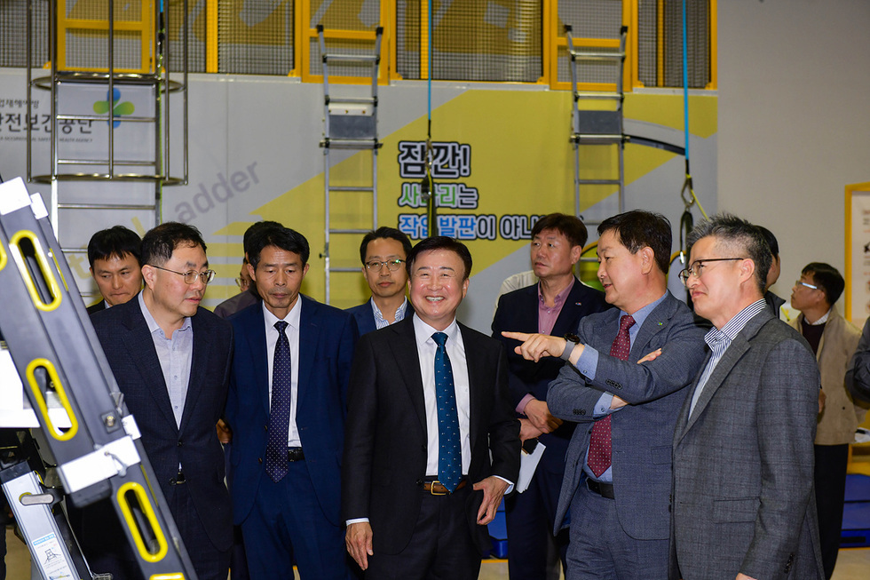 여러 명의 남성이 실내에서 대화하며 웃고 있는 모습으로, 배경에는 '사라지는 작별판이 아니다'라는 문구가 적힌 현수막이 보인다.