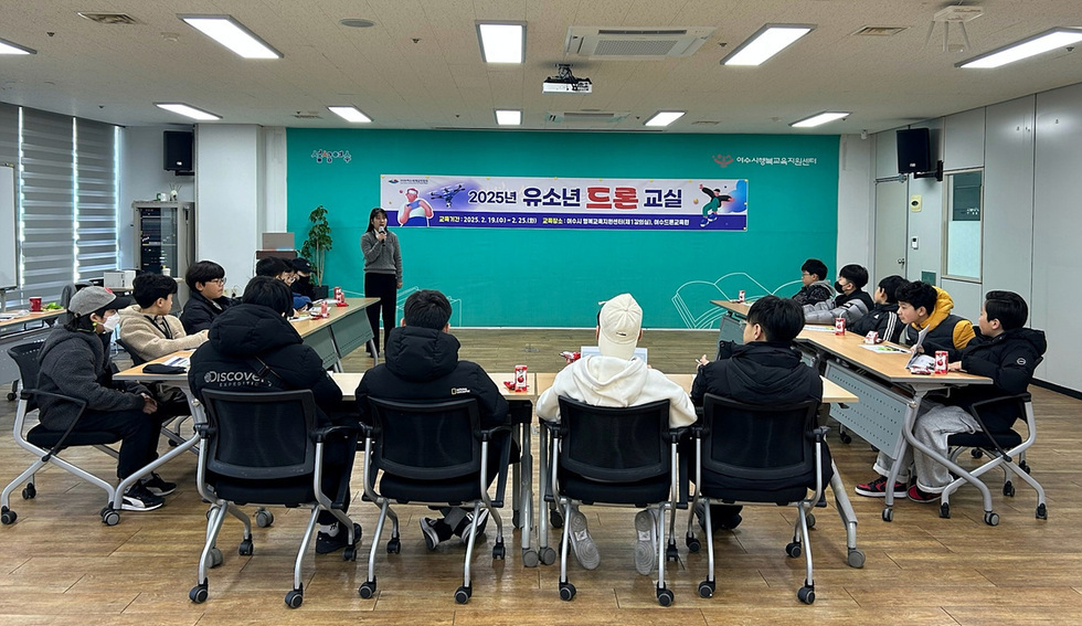 2025년 유소년 드론 교실에서 강사가 학생들에게 교육을 진행하고 있으며, 학생들은 강의를 듣고 있다.