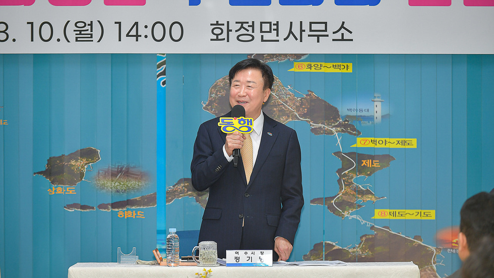 화정면사무소에서 정기환 시장이 마이크를 들고 발언하고 있는 모습이다. 배경에는 지역 지도가 보인다.