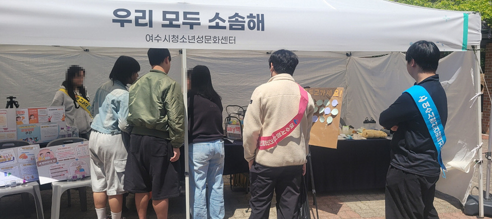 여수시청소년성문화센터의 부스 앞에서 청소년들이 정보를 얻고 있는 모습이다.