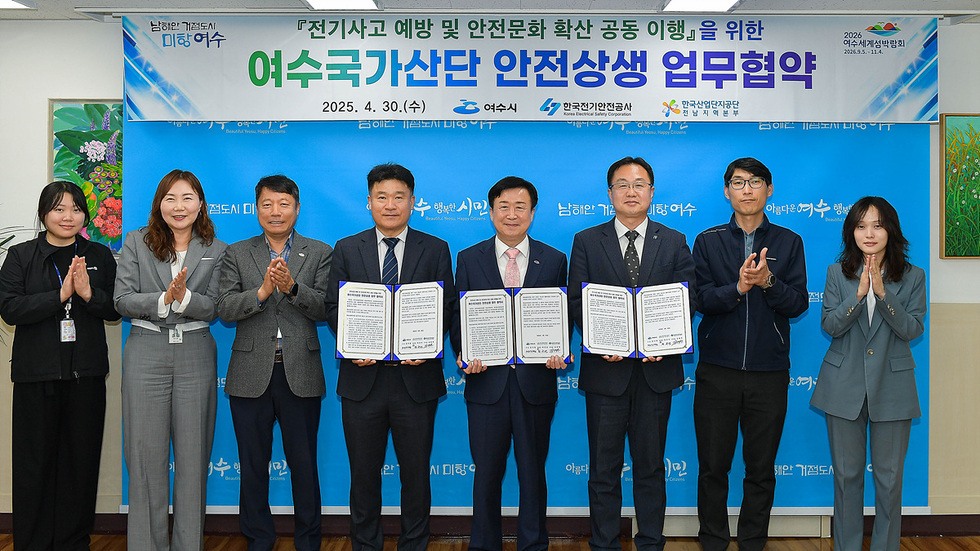 여수에서 전기사고 예방과 안전문화 확산을 위한 업무협약을 체결하는 장면으로, 여러 관계자들이 협약서를 들고 서 있다.