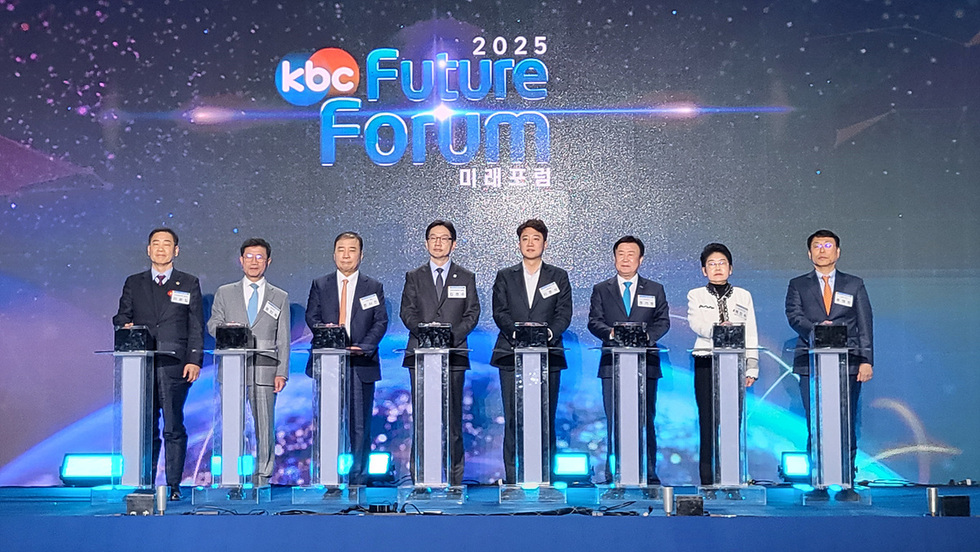 무대 위에 정장 차림의 주요 참석자 9명이 나란히 서서 발광 장치를 터치하는 세리머니 장면. 배경 화면에는 ‘2025 KBC Future Forum 미래포럼’ 문구가 표시돼 있다.