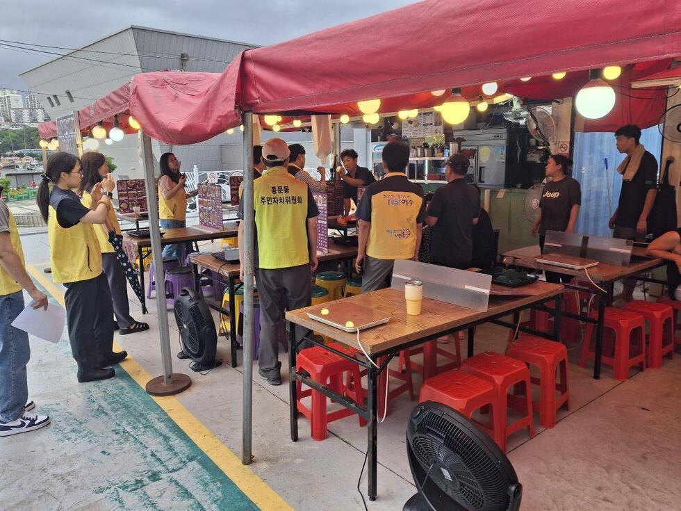 여수시 단속반 직원들이 포장마차 업주와 대화를 나누며 1회용품 사용 지도단속 내용을 안내하고 있는 현장 점검 모습