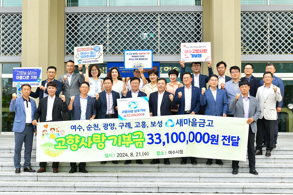 여수시청 앞에서 여수·순천·광양·구례·고흥·보성 새마을금고 임직원들이 모여 고향사랑기부금 3,310만 원 전달식을 진행하며 기념촬영을 하는 모습. 참가자들이 현수막을 들고 파이팅을 외치고 있다