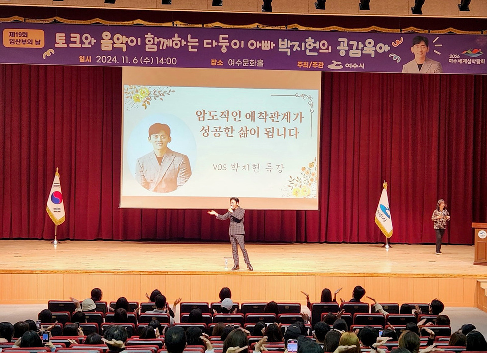 여수문화홀에서 박지현이 특강을 진행하고 있으며, 청중이 그를 바라보고 있다. 배경에는 행사 제목과 일시, 장소 정보가 적혀 있다.