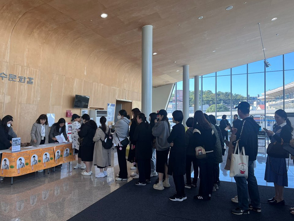 수문학관 내부에서 사람들이 줄을 서서 대기하고 있으며, 안내 데스크에서 직원들이 방문객을 맞이하고 있다.