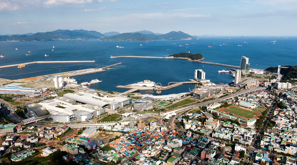 부산의 항구와 주변 경관을 조망한 항공 사진으로, 바다와 배들이 보이며 해안선과 도시 건물들이 함께 담겨 있다.