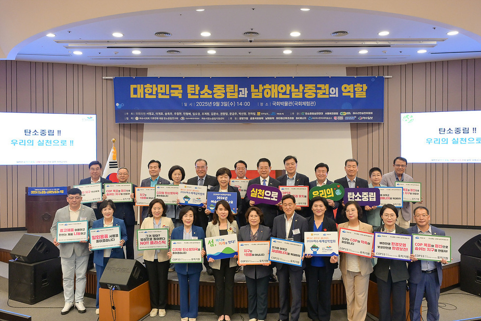 국회에서 열린 대한민국 탄소중립과 남해안남중권의 역할 행사에서 참석자들이 탄소중립 관련 현수막을 들고 있다.