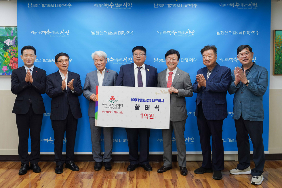 여수시장에서 황태식 대표가 아너 소사이어티 가입식에서 1억 원 기부 판넬를 들고 참석자들과 함께 기념사진을 찍고 있다.