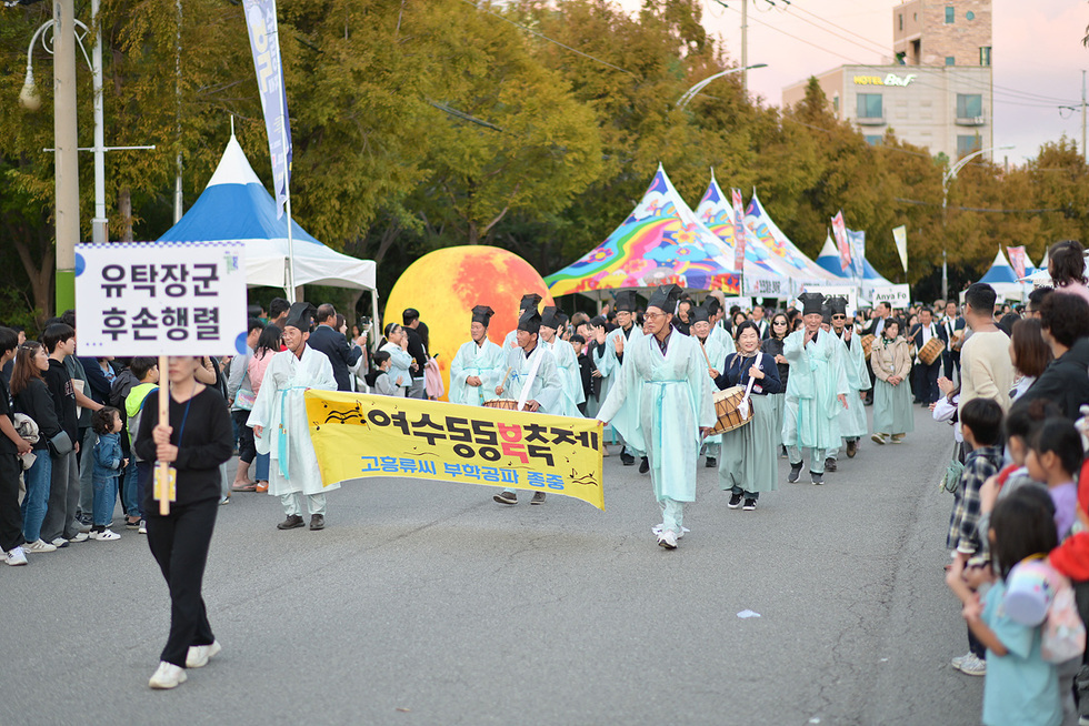 여수동동북축제에서 참가자들이 행진하며 축제를 즐기는 모습으로, 유택장군 후손행렬이 진행되고 있다.