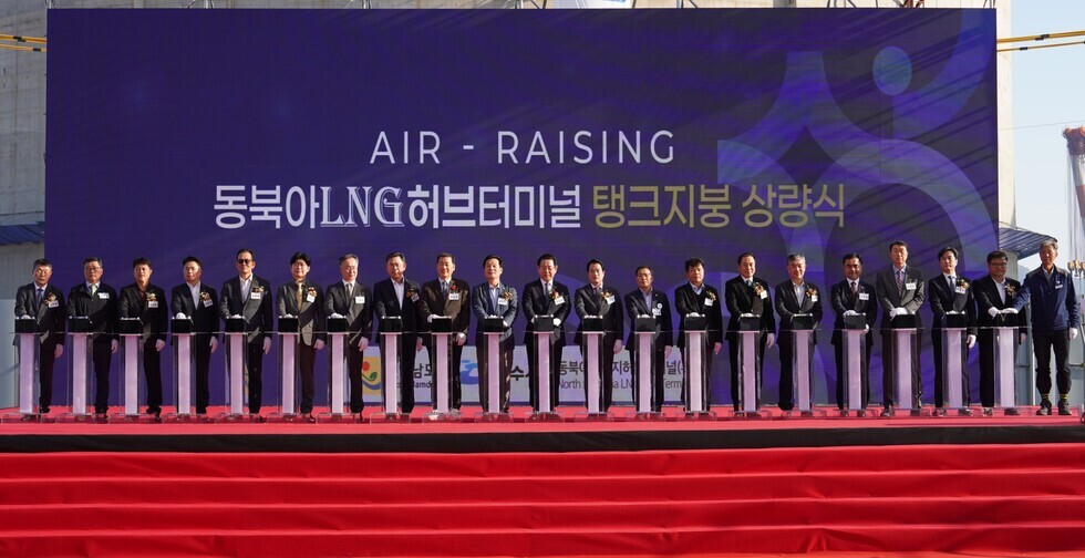 대형 무대 배경에 ‘AIR-RAISING 동북아LNG허브터미널 탱크지붕 상량식’ 문구가 표시된 행사장에서 주요 내빈들이 단상 위에 서서 점등 버튼을 누르며 상량식을 진행하는 모습